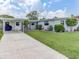 Beautifully landscaped front yard with a well-maintained lawn and attached carport on a sunny day at 1685 Kissengen Ave, Bartow, FL 33830