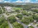An aerial view of a neighborhood with tree-lined streets, homes, and a large school building nearby a lake at 1715 Lando Ln, Orlando, FL 32806