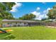 Expansive backyard with lush green grass, playground, screened porch and mature trees is ready for fun and relaxation at 1715 Lando Ln, Orlando, FL 32806