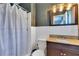 A full bathroom showcases a shower with curtain, granite vanity and backsplash, and white tiled walls at 1715 Lando Ln, Orlando, FL 32806