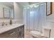 A modern bathroom featuring a marble vanity, framed mirror, and a shower with a patterned curtain at 1715 Lando Ln, Orlando, FL 32806