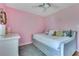 A bright bedroom with pink walls, a daybed, and a soft gray rug at 1715 Lando Ln, Orlando, FL 32806