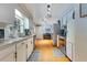Open kitchen area featuring stainless appliances, updated lighting, and access to the laundry room at 1715 Lando Ln, Orlando, FL 32806