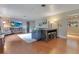 Open-concept living room with wood-look floors, a large screen TV, and a modern dining table with stools at 1715 Lando Ln, Orlando, FL 32806