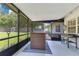 A large screened patio is perfect for outdoor entertaining with space for a grill and seating at 1715 Lando Ln, Orlando, FL 32806