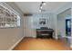 Flex room with a piano, wood-look tile flooring, and a view to the laundry room at 1715 Lando Ln, Orlando, FL 32806
