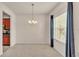 Bright dining room featuring modern chandelier, plush carpet, and natural light from a large window at 1975 Country Manor St, Bartow, FL 33830