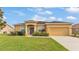Charming single-story home with a well-manicured lawn and a two-car garage on a sunny day at 1975 Country Manor St, Bartow, FL 33830