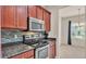 Chef's kitchen with stainless steel appliances, granite counters, modern microwave and glass tile backsplash at 1975 Country Manor St, Bartow, FL 33830