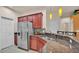 Spacious kitchen with stainless steel refrigerator, granite countertops, and stylish hanging pendant lights at 1975 Country Manor St, Bartow, FL 33830