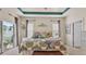Spacious main bedroom with a decorative tray ceiling, large bed, and sliding glass doors to the outside at 1975 Country Manor St, Bartow, FL 33830