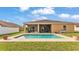 Backyard featuring a sparkling in-ground pool with lush landscaping and a screened-in patio for relaxing at 1975 Country Manor St, Bartow, FL 33830