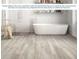 Modern bathroom features a soaking tub, vinyl plank flooring, and decorative white brick at 2230 Oldham Ct, Haines City, FL 33844