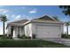 Charming single-story home with a two-car garage, well-manicured lawn, and lush landscaping at 2230 Oldham Ct, Haines City, FL 33844
