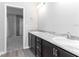 Bathroom with dual sinks, marble countertop, wood cabinets, and view to bedroom at 2234 Oldham Ct, Haines City, FL 33844
