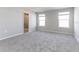 Spacious bedroom with gray carpet, two windows, and ensuite bathroom with glass shower at 2234 Oldham Ct, Haines City, FL 33844