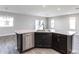 The island features a stainless steel dishwasher, dark cabinets, and a gray countertop at 2234 Oldham Ct, Haines City, FL 33844