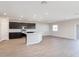 A large kitchen and living space with dark cabinets, stainless appliances, and wood-look floors at 2234 Oldham Ct, Haines City, FL 33844