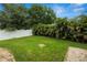 A manicured backyard with green grass, tropical plants, and a white fence at 228 Magneta Loop, Auburndale, FL 33823