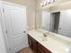 A bathroom featuring a dark wood vanity with a light countertop and a large mirror at 228 Magneta Loop, Auburndale, FL 33823
