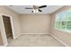 Neutral bedroom features plush carpeting, a ceiling fan, a window with blinds, and a walk-in closet at 228 Magneta Loop, Auburndale, FL 33823