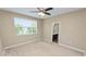 A bright bedroom with a neutral palette featuring a window with blinds and an ensuite bathroom at 228 Magneta Loop, Auburndale, FL 33823