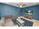 Comfortable bonus room features a sofa, a coffee table, a television with storage, and a modern ceiling fan at 228 Magneta Loop, Auburndale, FL 33823