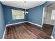 Bright dining room featuring hardwood floors, blue walls, a modern chandelier, and a large window at 228 Magneta Loop, Auburndale, FL 33823