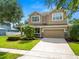 Charming two-story home featuring a two car garage, landscaped yard, and a well-maintained lawn at 228 Magneta Loop, Auburndale, FL 33823