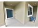 Inviting front porch with a blue accent bench and a view of the manicured lawn at 228 Magneta Loop, Auburndale, FL 33823