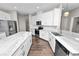 Modern kitchen features white cabinets, stainless steel appliances, and marble countertops at 228 Magneta Loop, Auburndale, FL 33823