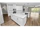 Bright, open kitchen with white cabinets, granite countertops, stainless steel appliances, and a center island at 228 Magneta Loop, Auburndale, FL 33823