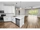 Open kitchen with stainless steel appliances, countertop seating, and a view into the living space at 228 Magneta Loop, Auburndale, FL 33823