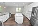 Bright open-concept kitchen with a large center island, stainless appliances, and pendant lighting at 228 Magneta Loop, Auburndale, FL 33823