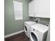 Bright laundry room featuring modern, white appliances, cabinets and natural light at 228 Magneta Loop, Auburndale, FL 33823