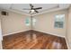 Main bedroom with hardwood floors, a ceiling fan, and three windows for natural light at 228 Magneta Loop, Auburndale, FL 33823