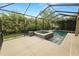 Screened-in pool and spa area featuring a tiled spa with a water feature surrounded by tropical landscaping at 228 Magneta Loop, Auburndale, FL 33823
