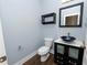 Powder room with a unique bowl sink, a vanity, a floating wall shelf, and a toilet at 228 Magneta Loop, Auburndale, FL 33823