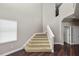 Carpeted staircase with white handrail ascends past a window to the upper level at 228 Magneta Loop, Auburndale, FL 33823