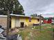 Exterior view of a yellow single-story home with a metal roof and a partially painted wall at 2293 Pump Rd, Mulberry, FL 33860