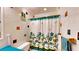 Bright, quirky bathroom featuring white tile with colorful accents and a floral shower curtain at 2333 Cheshire Pl, Lakeland, FL 33810