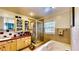 This bathroom provides a separate shower, jacuzzi tub, and bright vanity lighting at 2333 Cheshire Pl, Lakeland, FL 33810