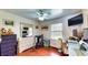 Well lit bedroom featuring a ceiling fan, a workstation, and laminate wood flooring at 2333 Cheshire Pl, Lakeland, FL 33810