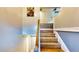 Interior stairway design featuring wood steps, white risers, a wooden handrail, and neutral wall colors at 2333 Cheshire Pl, Lakeland, FL 33810