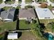 Aerial view showcasing a home's backyard, fencing, patio, landscaping, pool, and shed in a neighborhood at 244 Kings Pond Ave, Winter Haven, FL 33880