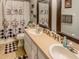 Bathroom with a double vanity, two framed mirrors, and decorative shower curtain at 244 Kings Pond Ave, Winter Haven, FL 33880