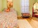 Cozy bedroom with floral bedding, wood floors, and a patterned accent chair at 244 Kings Pond Ave, Winter Haven, FL 33880