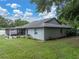 A spacious backyard showing the exterior of the home and the enclosed patio at 257 Padgett N Pl, Lakeland, FL 33809