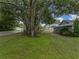 Fenced backyard with grass, shade tree and partial house view at 257 Padgett N Pl, Lakeland, FL 33809