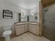 Bathroom featuring dual sinks, modern fixtures, and tiled shower with glass door at 257 Padgett N Pl, Lakeland, FL 33809